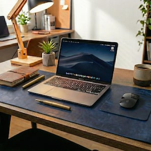 Deep navy full grain leather desk mat with slightly distressed surface, laptop and mouse placed at center