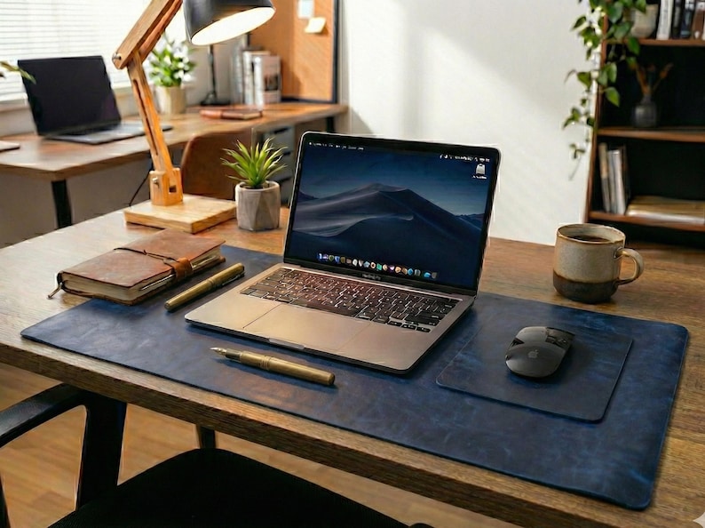 Deep navy full grain leather desk mat with slightly distressed surface, laptop and mouse placed at center