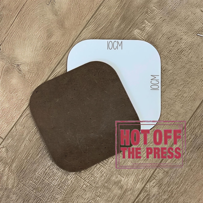 a brown square object placed on a wooden surface, with a white rectangular object above it. There is a red text overlay that says "HOT OFF THE PRESS".