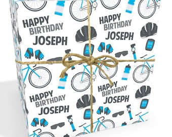 May include: A stack of white wrapping paper with a blue and gray bicycle themed pattern. The paper features a repeating pattern of bicycles, helmets, water bottles, sunglasses, and gloves. The text "Happy Birthday Joseph" is repeated throughout the pattern.