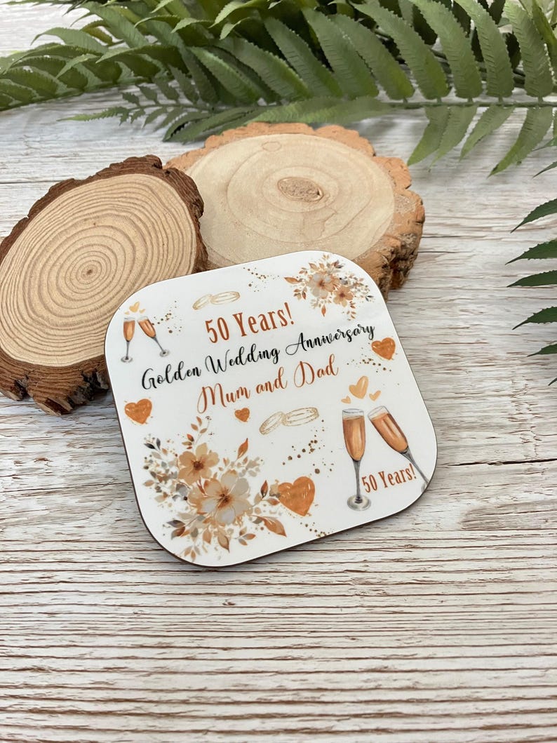 A 50th anniversary coaster with a floral design and champagne glasses, celebrating the golden wedding anniversary of a mother and father.
