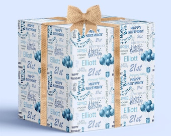 May include: A square gift box wrapped in white paper with a repeating blue pattern featuring the text Happy Birthday, 21st, and Elliott, along with illustrations of balloons and bunting, finished with a textured tan burlap ribbon bow.