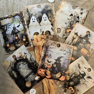 Könnte beinhalten: Ein Set aus acht Halloween-Stickkarten mit verschiedenen gruseligen Bildern, darunter Geister, Hexen, Kürbisse und ein Spukhaus. Jede Karte hat mehrere Löcher zum Einfädeln von Stickgarn.