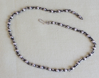 May include: A silver chain necklace with a simple ball chain design. The chain is approximately 18 inches long and features a lobster clasp fastening.
