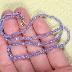 May include: A delicate necklace made of small, faceted amethyst beads. The necklace is strung on a thin gold chain and has a simple clasp.