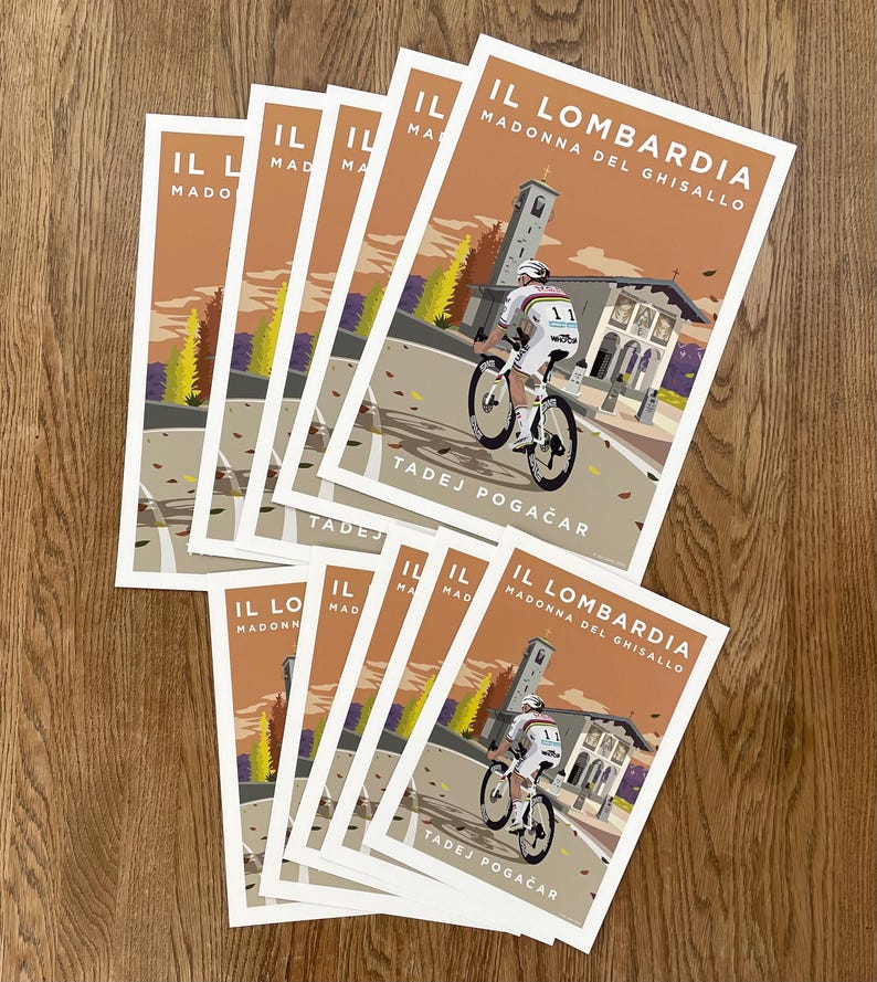 May include: A stack of eight cycling posters with a brown background and a cyclist riding a bicycle on a road with a church in the background. The text on the poster reads "IL LOMBARDIA MADONNA DEL GHISALLO TADEJ POGAČAR".
