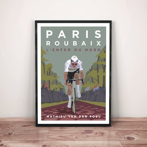 Puede incluir: Impresión artística enmarcada que representa a un ciclista en una carrera. El póster dice "PARIS ROUBAIX L'ENFER DU NORD" encima del ciclista y "MATHIEU VAN DER POEL" debajo. El ciclista lleva un uniforme blanco y negro y monta en una bicicleta blanca sobre una carretera roja.