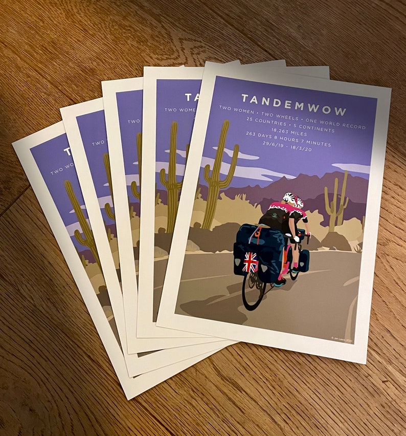 TandemWoW Guinness World Record Holders Cycling Prints showing the women tandem cyclists riding through a desert with cacti and mountains on their world record breaking challenge.