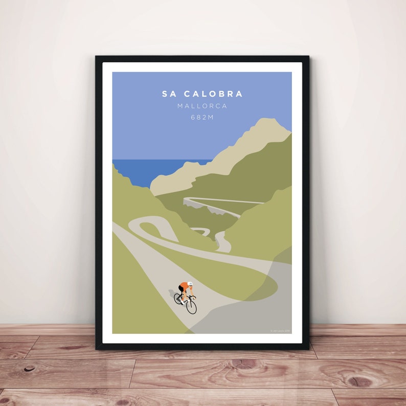 May include: A poster with a minimalist illustration of a cyclist riding up a winding road in the mountains. The poster is titled "Sa Calobra, Mallorca, 682m".