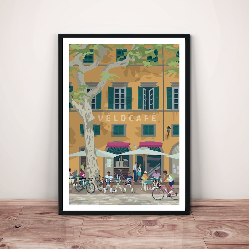 An evocative print of a sun-dappled European Cafe, with yellow wall, pink awnings and green shutters. A grey bark tree framing the image. People are sitting at tables including two male cyclists who have stopped for a break. Female cyclist riding by.