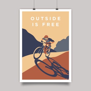 May include: A poster with a mountain landscape and a person riding a mountain bike. The poster has the text "OUTSIDE IS FREE" in white letters on a light orange background.