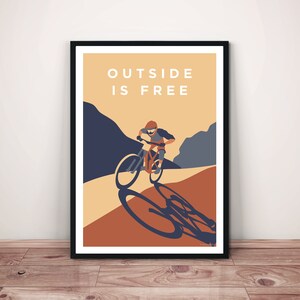 May include: A poster with a mountain biking illustration and the text "OUTSIDE IS FREE". The poster has a brown, orange, and blue color scheme.