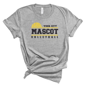 May include: Gray t-shirt with a yellow volleyball graphic and the text "YOUR CITY MASCOT VOLLEYBALL".