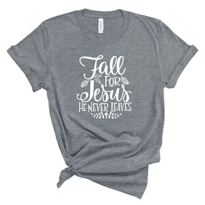 May include: Gray t-shirt with white text that reads "Fall for Jesus He Never Leaves" with a small leaf design.