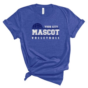 May include: A royal blue t-shirt with a white volleyball graphic and the text "YOUR CITY MASCOT VOLLEYBALL".