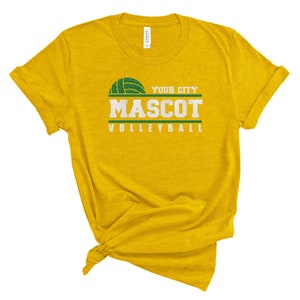 May include: Yellow t-shirt with a green volleyball graphic and the text "YOUR CITY MASCOT VOLLEYBALL".