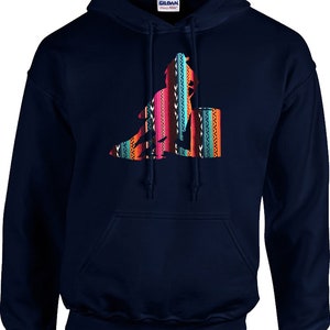 May include: A navy blue hooded sweatshirt featuring a colourful graphic of a person riding a barrel horse. The graphic is in a southwestern style with bright colours and geometric patterns.