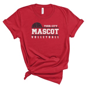 May include: Red t-shirt with a black volleyball graphic and the text "YOUR CITY MASCOT VOLLEYBALL".