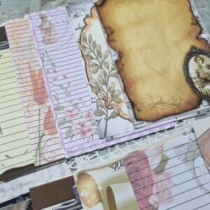 Könnte beinhalten: Eine Sammlung von Papier-Ephemera im Vintage-Stil mit liniertem Papier, Blumenmustern und einem dekorativen Rahmen mit einem Frauenporträt. Die Papiere eignen sich perfekt zum Scrapbooking, Journaling oder Basteln.