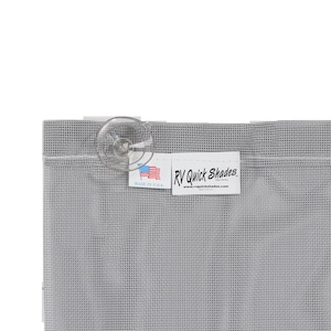 May include: A close-up of a gray RV Quick Shades screen with a clear suction cup attached. The screen has a grid-like pattern. A white tag with the text "RV Quick Shades" and "Made in U.S.A." is visible.