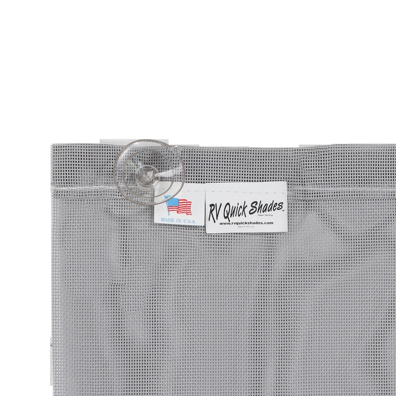 May include: A close-up of a gray RV Quick Shades screen with a clear suction cup attached. The screen has a grid-like pattern. A white tag with the text "RV Quick Shades" and "Made in U.S.A." is visible.