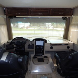 Beige RV windshield privacy shade material with suction cup for Class A motorhomes.