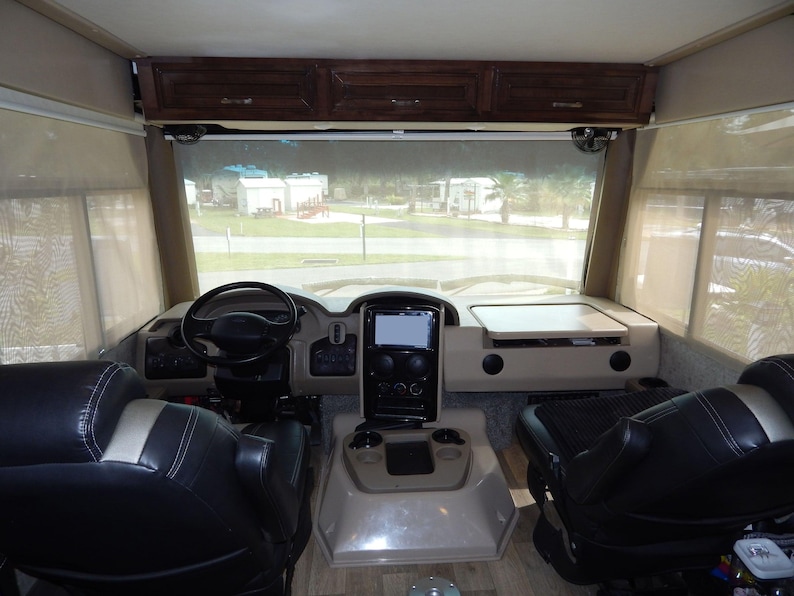 Beige RV windshield privacy shade material with suction cup for Class A motorhomes.