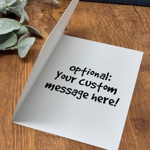 May include: Blank white card with the text "optional: your custom message here!" written in black marker.