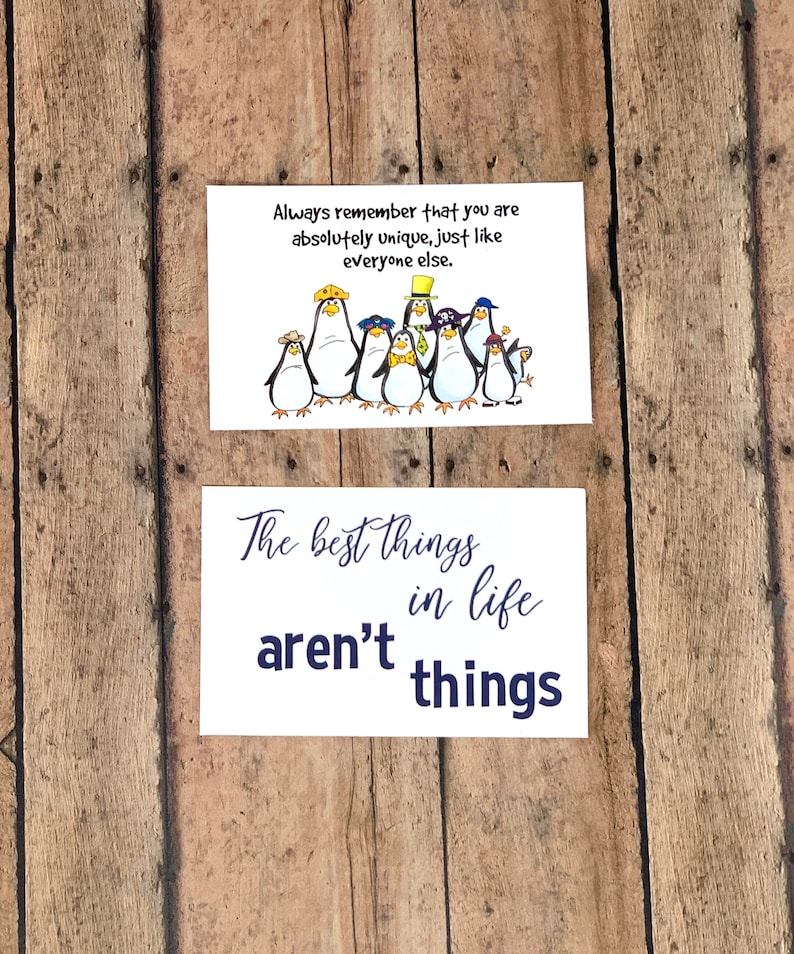 May include: Two white cards with blue text. The top card features a group of cartoon penguins wearing hats and the text "Always remember that you are absolutely unique, just like everyone else." The bottom card features the text "The best things in life aren't things."