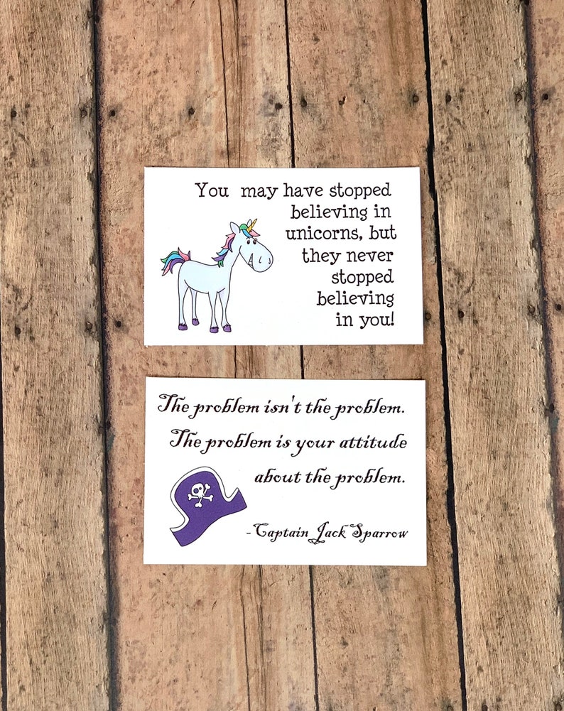 May include: Two inspirational quotes on white cards. The first card features a cartoon unicorn with the text "You may have stopped believing in unicorns, but they never stopped believing in you!" The second card features a cartoon pirate hat with the text "The problem isn't the problem. The problem is your attitude about the problem. - Captain Jack Sparrow"
