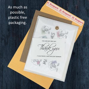 May include: An assortment of stationery items, including a thank you card with elegant script and a sheep illustration. The packaging includes a yellow envelope, a brown envelope, and a clear plastic sleeve. The text on the card reads "Thank you".