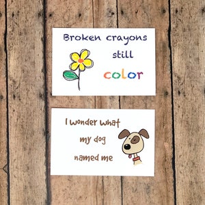 May include: Two cards with hand-drawn illustrations and text. The first card features a yellow flower with a green stem and leaves. The text reads "Broken crayons still color". The second card features a brown dog with a red collar and the text "I wonder what my dog named me".