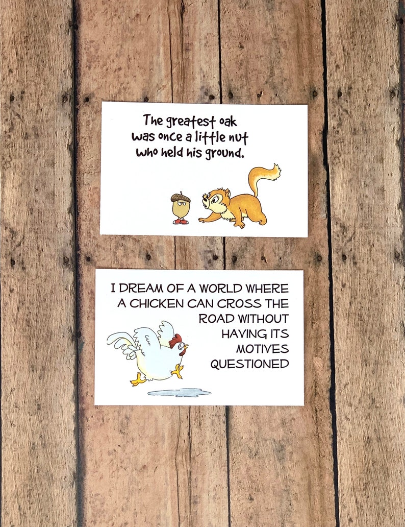 May include: Two illustrated cards with inspirational quotes. The first card features a cartoon acorn and squirrel with the text "The greatest oak was once a little nut who held his ground." The second card features a cartoon chicken crossing the road with the text "I dream of a world where a chicken can cross the road without having its motives questioned."