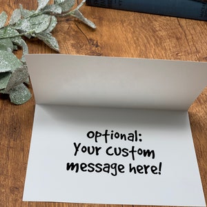 May include: Blank white card with the text "optional: your custom message here!" written in black marker.