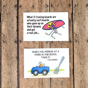 K&ouml;nnte beinhalten: Zwei illustrierte Karten mit humorvollen Spr&uuml;chen. Die obere Karte zeigt ein rosa und gelbes B&uuml;gelbrett mit einem Palmenbaum darauf und den Text "What if ironing boards are actually surf boards who gave up on their dreams and got a real job..." Die untere Karte zeigt ein blaues Auto mit einem Hund und einem B&auml;ren darin, das auf eine gro&szlig;e Gabel in der Stra&szlig;e zuf&auml;hrt. Der Text lautet "When you arrive at a fork in the road, take it. -Yogi Berra"