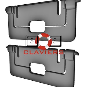 Könnte beinhalten: Zwei graue, rechteckige, scharnierartige Objekte mit einem Ausschnitt in der Mitte. Das Wort "CLAVIERS" ist rot gedruckt. Eine rot-weiße Rettungsring-Grafik befindet sich zwischen zwei schwarzen Quadraten mit dem weißen Buchstaben "S".