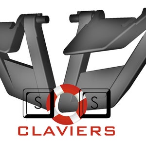 Könnte beinhalten: Zwei schwarze Kunststoffteile für eine Tastatur, jedes mit einer geschwungenen Form und einer kleinen rechteckigen Öffnung. Die Teile sind so konzipiert, dass sie die Tasten der Tastatur an Ort und Stelle halten.