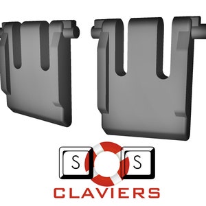 Op de afbeelding: Twee grijze, U-vormige, 3D-gerenderde objecten met afgeronde randen. De objecten hebben een rechthoekige basis en een gebogen bovenkant met een cilindrische uitsteeksel. Daaronder een logo met een toets en het woord "CLAVIERS".