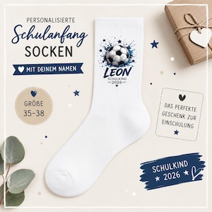 Könnte beinhalten: Eine weiße Socke mit einem Fußball-Motiv, umgeben von blauen Farbspritzern und Sternen. Der Text lautet LEON, SCHULKIND 2026, PERSONALISIERTE SCHULANFANG SOCKEN, MIT DEINEM NAMEN, GRÖBE 35-38, DAS PERFEKTE GESCHENK ZUR EINSCHULUNG, SCHULKIND 2026.