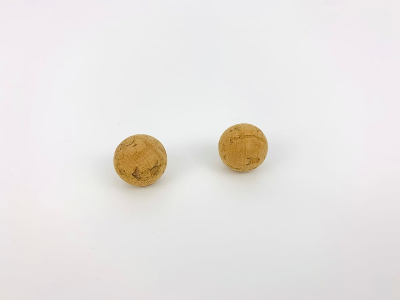 May include: Two brown cork balls on a white background.