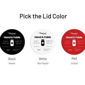 Pu&ograve; includere: Tre coperchi per barattoli con il testo "The Original Jar Games Hand & Fable" in nero su sfondo bianco. I coperchi sono nero, bianco e rosso. Il testo "Black", "White" e "Red" &egrave; sotto ogni coperchio. Il testo "Newest", "Most Popular" e "Original" &egrave; sotto i nomi dei colori.