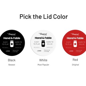 May include: Three round labels with the text "The Original Jar Games Hand & Fable" in black text on a white background. The labels are black, white, and red. The text "Black", "White", and "Red" is below each label. The text "Newest", "Most Popular", and "Original" is below the color names.