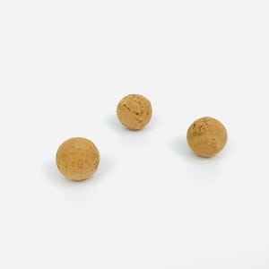May include: Three round cork balls, each with a natural brown color and a slightly rough texture.