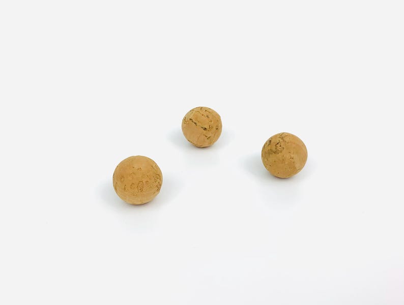 May include: Three round cork balls, each with a natural brown color and a slightly rough texture.