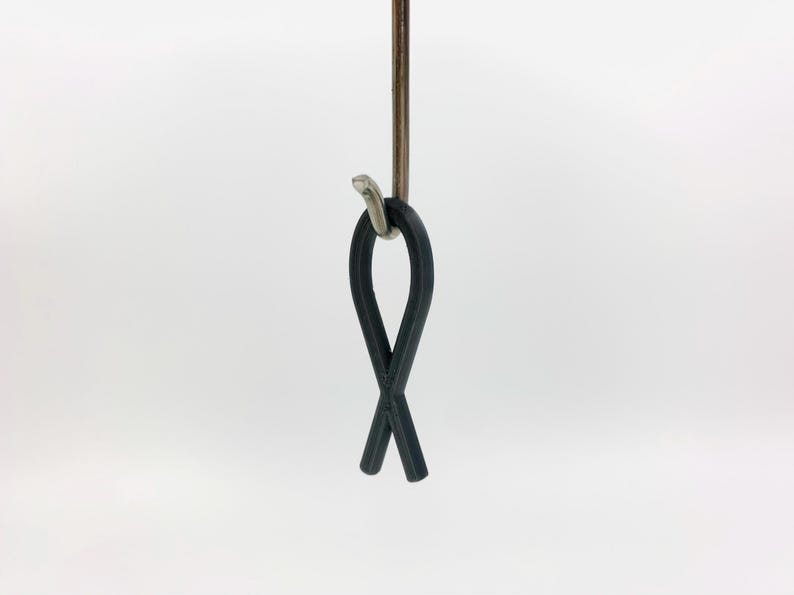 May include: A black rubber fish-shaped hook hanging from a silver hook.