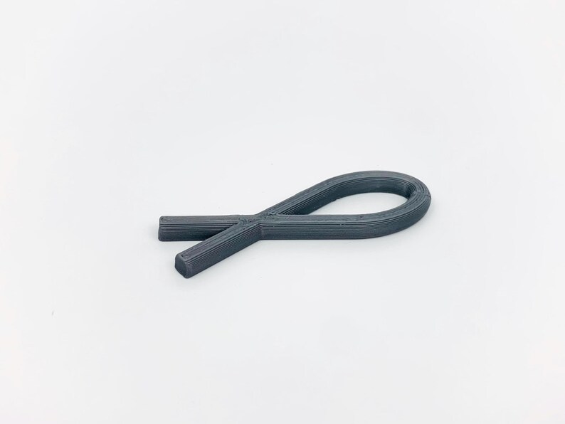 May include: A gray plastic ribbon shaped like a fish.
