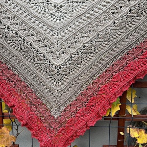 May include: A crocheted shawl with a gradient of colors from beige to red. The shawl is made with a delicate lace pattern and has a scalloped edge.