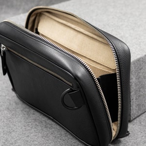 The Tech Pouch is handmade from full grain leather in black with an embossed pebble grain texture. We have also added D-Rings on the exterior to enable crossbody carry.