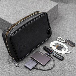The above image shows the back side of the zippered pouch. There is a D-Ring that along with the D-Ring on the opposite side helps to carry the pouch crossbody.