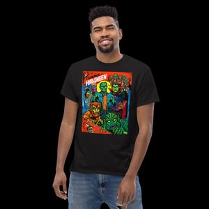 May include: A black t-shirt with a colorful graphic print of a comic book cover featuring a group of monsters. The comic book cover is titled "I Remember Halloween".